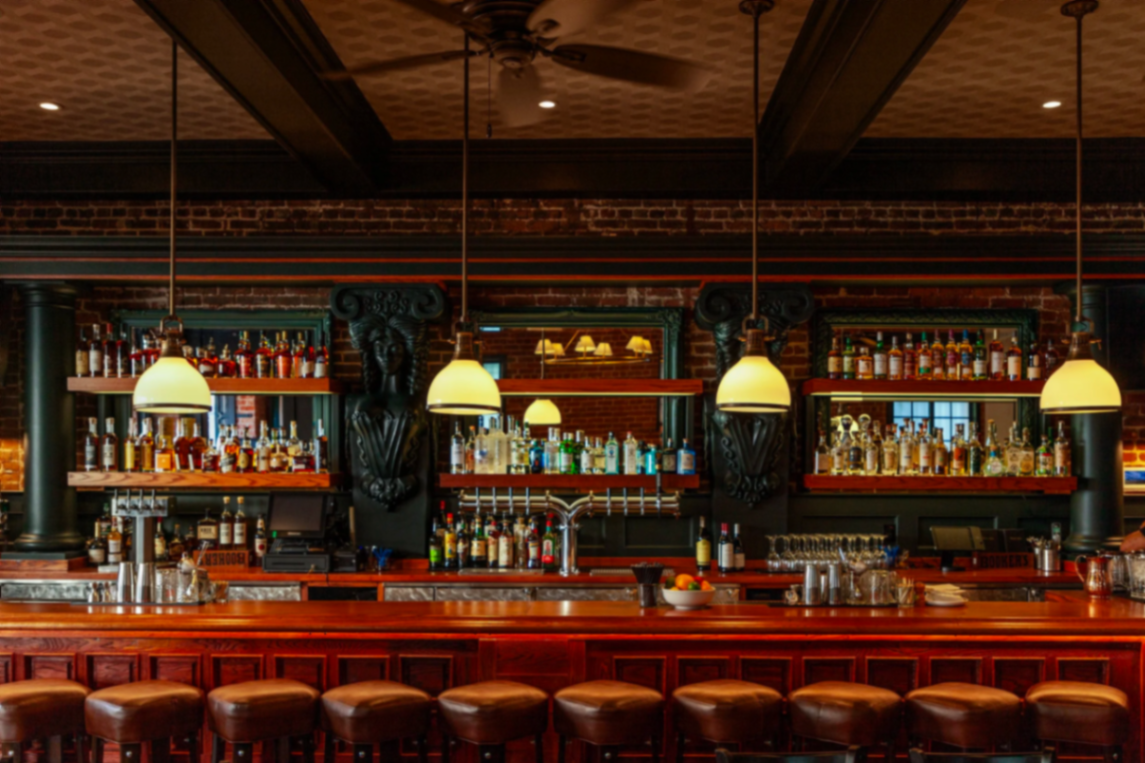 Grumpy's classic warm-wood bar with pendant lights and mirrors